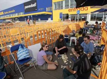 Caty Hamley, con otros tres clientes, juega al Rummikub para entretenerse en su espera.