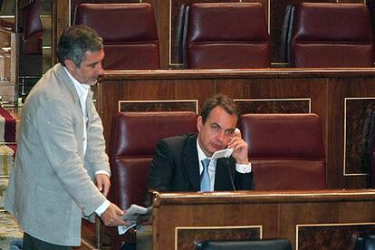 Gaspar Llamazares, líder de IU, conversa con José Luis Rodríguez Zapatero, secretario general del PSOE, en el hemiciclo del Congreso.