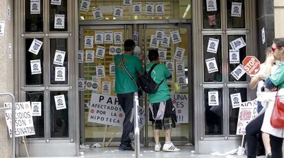 Activistas de la PAH, ante la sede ocupada de Bankia en Castellón.