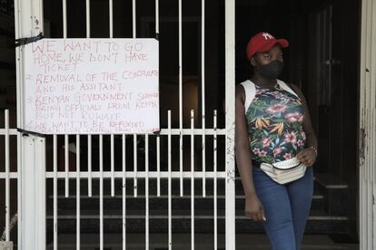 Una mujer keniana trabajadora en Beirut permanece junto a la embajada de Kenia en Beirut en medio de una protesta de migrantes kenianos que exigen la repatriación. "Queremos volver a casa pero no tenemos billetes [de avión]" se lee en la pancarta.