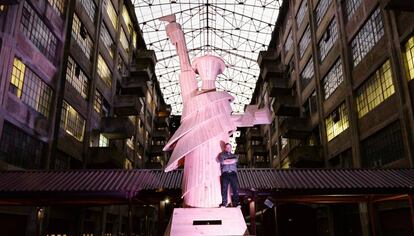 Pedro Reyes aparece junto a la Estatua de la libertad, que evoca al Caballo de Troya.