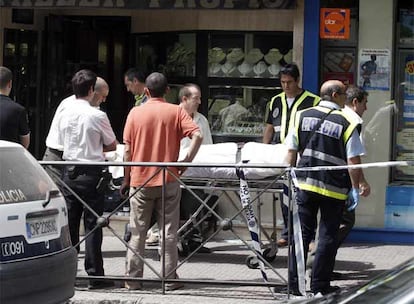 La policía traslada el cadáver del joyero degollado ayer en su establecimiento de Leganés.