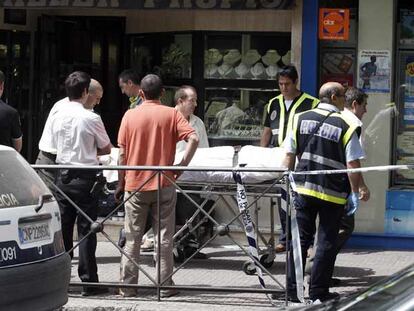 La policía traslada el cadáver del joyero degollado ayer en su establecimiento de Leganés.