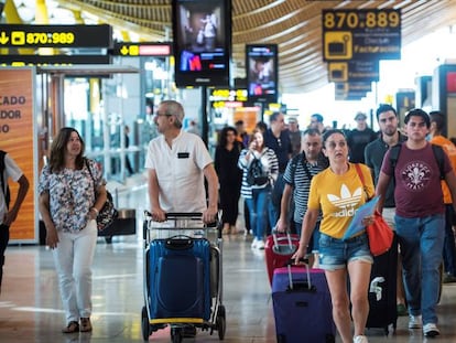 Viajeros transitan por la terminal 4 del aeropuerto de Barajas al inicio de las vacaciones del mes de agosto, el miércoles.