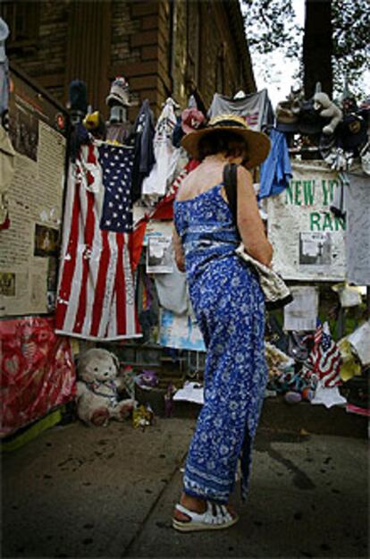 Una mujer observa recuerdos en memoria de los desaparecidos en las Torres Gemelas de Nueva York. PLANO GENERAL - ESCENA
