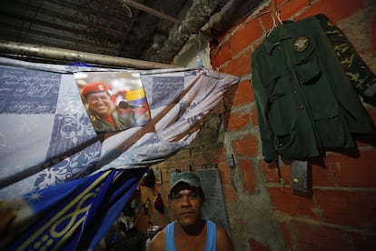 Carteles de Chávez, bajo la frase "Comandante Eterno", adornan las paredes del edificio. En la imagen, José Aular posa con el retrato del expresidente el interior de su apartamento. Fotografía tomada el 6 de febrero 2014.