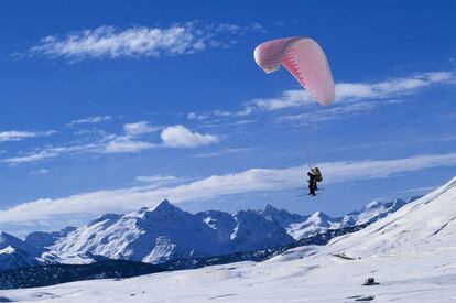 Un parapente biplaza sobrevuela los paisajes nevados de Baqueira Beret, en el Pirineo catalán. Además de esta actividad, en los últimos años se ha extendido otra variante deportiva, el 'speed riding', que combina el esquí con el parapente en una especia de 'kitesurf' sobre la nieve.