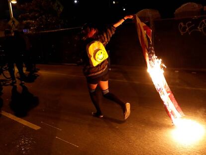 Un manifestante con una bandera en llamas despu&eacute;s de la elecci&oacute;n de Trump, en California.