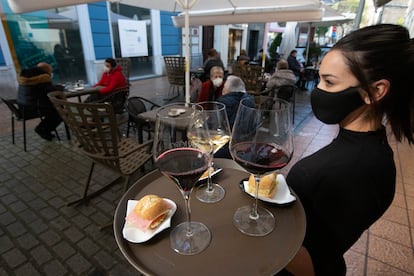 Una camarera se dispone a servir en una terraza de un restaurante de Avilés (Asturias) el pasado lunes.