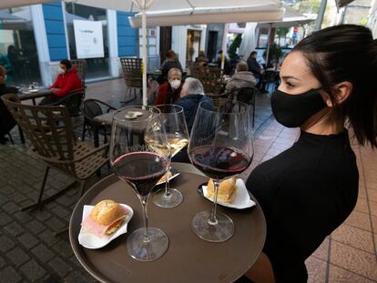 Una camarera se dispone a servir en una terraza de un restaurante de Avilés (Asturias) el pasado lunes.