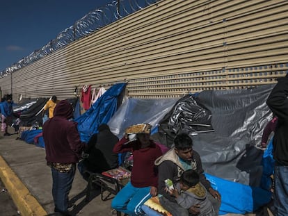 Un grupo de migrantes aguarda en un campamento improvisado frente al muro fronterizo en San Luis Río Colorado, en Sonora.