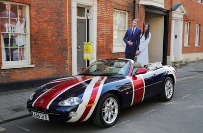 Un Jaguar con la bandera de Reino Unido con dos figuras de cartón de Enrique y Meghan Markle en su interior aparcado cerca del castillo de Windsor. 