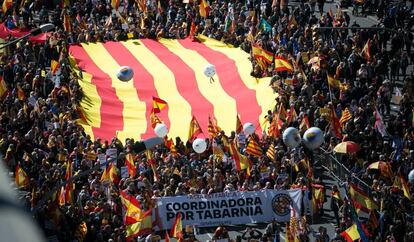 Una enorme bandera de Cataluña es llevada por manifestantes.