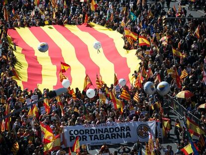 Una enorme bandera de Cataluña es llevada por manifestantes.