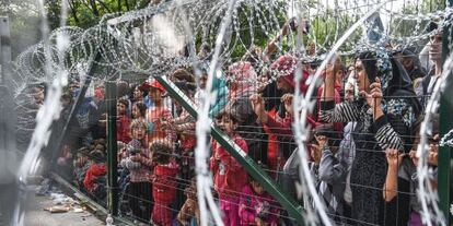Refugiados esperan frente a una cerca de la frontera entre Hungría y Serbia, cerca de la localidad de Horgos, el pasado septiembre.