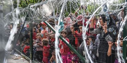 Refugiados esperan frente a una cerca de la frontera entre Hungr&iacute;a y Serbia, cerca de la localidad de Horgos, el pasado septiembre.