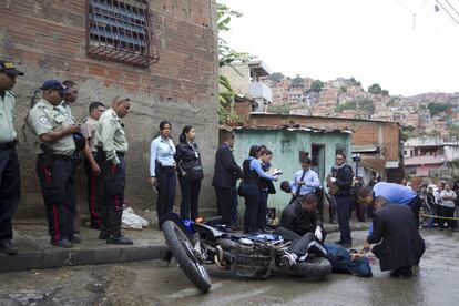 Agentes de policía inspeccionan el cuerpo de un hombre asesinado en un tiroteo en una calle de Caracas, en 2019.