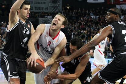 El escolta lituano del Olympiacos, Martynas Gecevicius intenta eludir la defensa del pívot croara Marko Banic, del escolta letón Janis Blums y del pívot estadounidense D'Or Fischer, todos del Bizkaia Bilbao Basket, en el partido correspondiente a la primera jornada de la Euroliga, grupo A que se disputa esta noche en el Bilbao Arena.