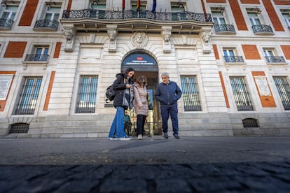 Turistas frente a la fachada de la Real Casa de Correos, sede del gobierno de la Comunidad de Madrid, en la Puerta del Sol.