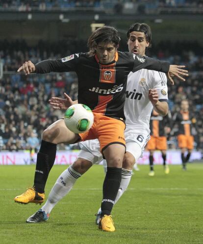 Sami Khedira pelea el balón con el centrocampista argentino del Valencia Ever Banega.
