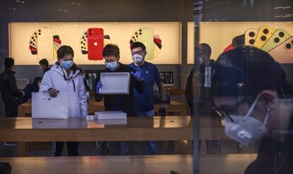 Dependientes atienden en una tienda de Apple en Pekín.