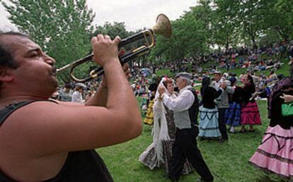 Los chulapos y las chulapas bailan en la tradicional romería del santo, en la pradera de San Isidro.