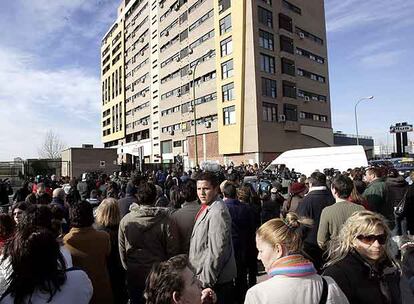 Vecinos de Valdebernardo, junto al edificio donde tenía su domicilio Érika Ortiz, tras conocer la noticia de su fallecimiento.