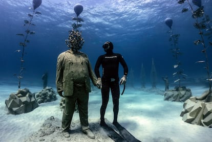 El buceador Angelos Savvas posa con una escultura submarina en Chipre en 2021.