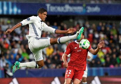 Rafael Varane y el centrocampista argentino del Sevilla Franco Vázquez compiten por el balón.