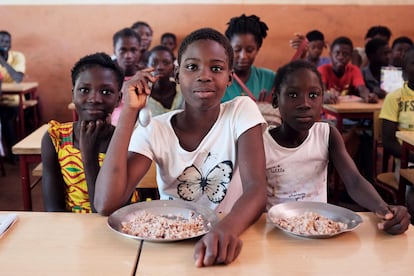 Un grupo de estudiantes come en el comedor de su escuela en Ginea-Bissau.