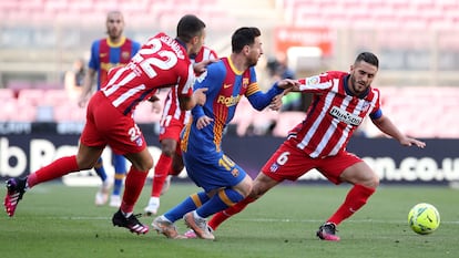 Messi trata de regatear a Mario Hermoso (izquierda) y Koke este sábado en el Camp Nou.