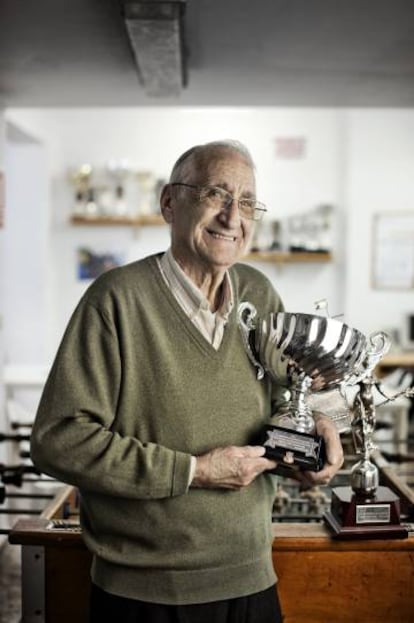 Julio Talavera, de 75 años, posa en la sede del club con algunos de los trofeos de sus chicos.