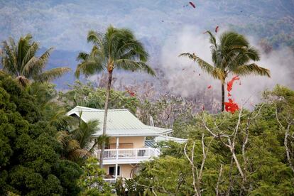 Humo y lava se elevan por encima de una casa en las afueras de Pahoa, Hawái, durante la erupción del volcán Kilauea, el 14 de mayo de 2018.