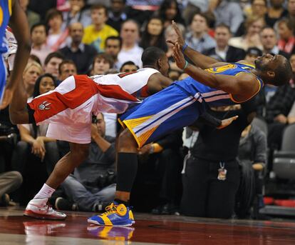 El jugador de Raptors Terrence Ross (i) choca con Carl Landry (d), de los Warriors.