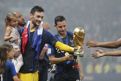 El portero francés Hugo Lloris sujeta la Copa del Mundo junto a sus familiares. 