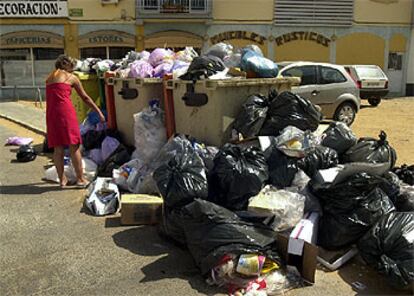 Una vecina, ayer, arroja su basura en Chiclana de la Frontera.