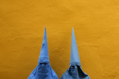 Penitentes de la hermandad de San Esteban posantes de participar en una procesión en la Semana Santa en Sevilla.