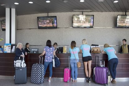 Varios turistas se registran en la recepción de un hotel de Benidorm.