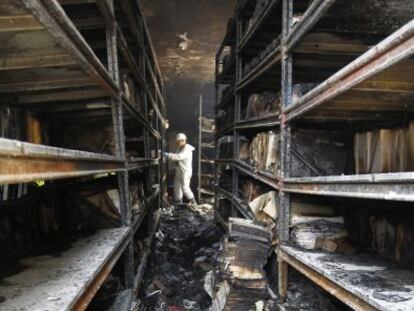 Un agente de la Guardia Civil trabaja en el archivo de Los Palacios, arrasado por el fuego.