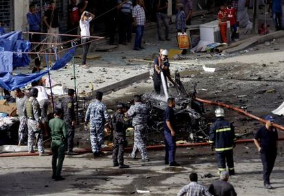 La policía inspecciona el lugar donde ha estallado una bomba en Bagdad hoy.