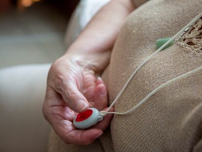 Una mujer presiona el botón rojo del dispositivo de teleasistencia el 6 de enero de 2024.
