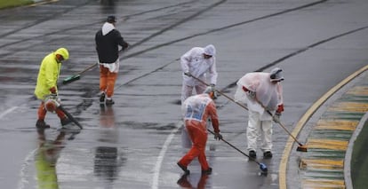 Cinco operarios intentan despejar de agua el circuito.