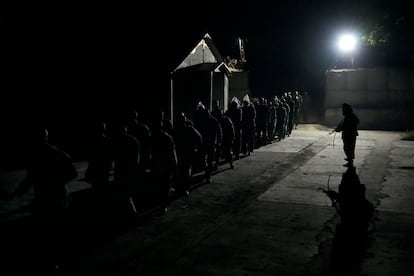 Vigilados por un talibán armado, varios detenidos caminaban en fila hacia la sala de desintoxicación de un campo de tratamiento de adicción a las drogas en Kabul, el 31 de mayo.