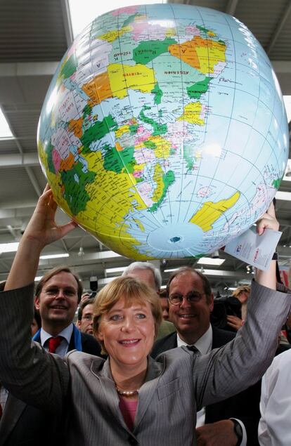 Angela Merkel, líder de la Unión Democristiana de Alemania (CDU), levanta un globo terráqueo inflable durante su visita al Protestan Kirchentag (día de la iglesia) en Hanover, el 26 de mayo de 2005.