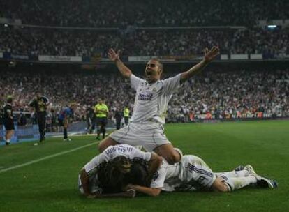 Cannavaro, Salgado y Sergio Ramos abrazan en el césped a Diarra tras el segundo gol.