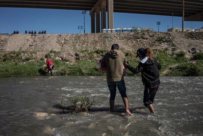 Una familia cruza el río Bravo en Ciudad Juárez, en México, para entregarse voluntariamente a la Patrulla Fronteriza en El Paso, en Estados Unidos.