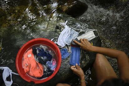 Una mujer lava mascarillas en El Cerro El Ávila de Caracas (Venezuela).