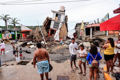 Pobladores observan una vivienda derrumbada por el paso del huracán 'John'.