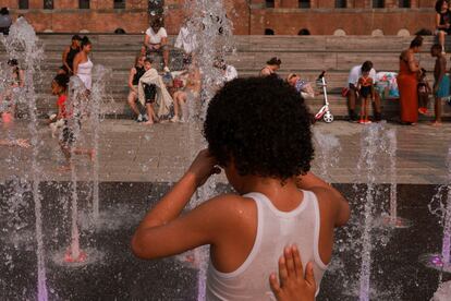 Algunos niños se refrescan en un parque de Brooklyn en la ciudad de Nueva York, este lunes.  