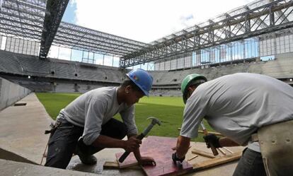 Oper&aacute;rios trabalham nas obras da Arena da Baixada.